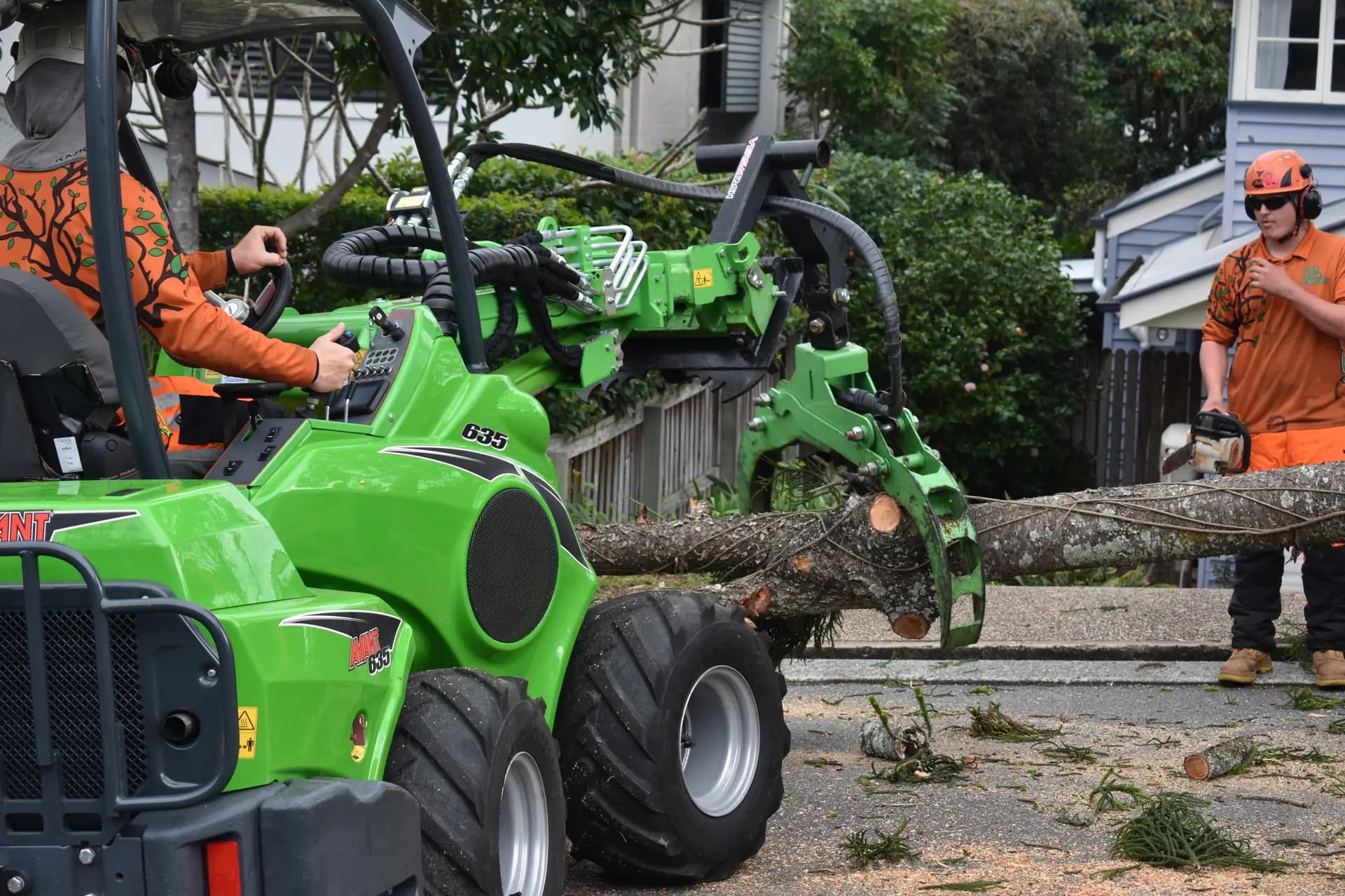 A compact loader carrying cut logs out to the truck
