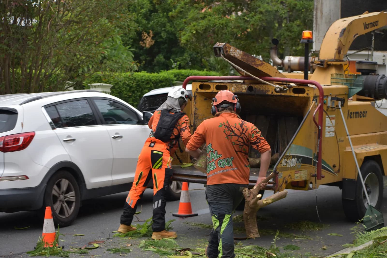 Crew feeding branches into the chipper on a residential street